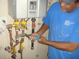 Plumbers install tankless water heater for happy customer